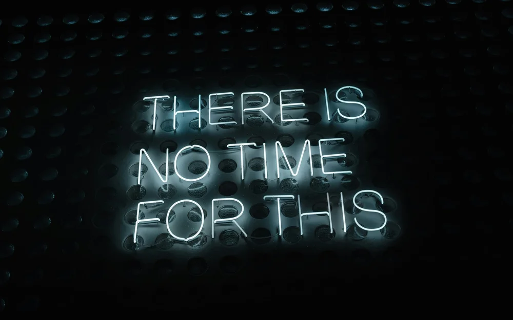Neon sign reading ‘There is no time for this’