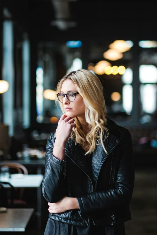 Woman in glasses thinking in a café